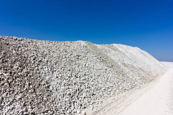 Un gran montículo de piedra caliza triturada contra el cielo azul — Foto de Stock