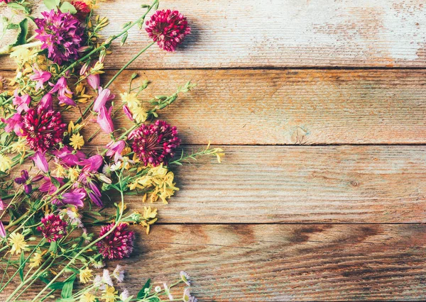 Wildflowers on wooden retro grunge background with space for text — Stock Photo, Image