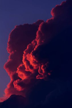 Arka plan, manzara ile akşam gökyüzünde batan güneşin ışınlarını kırmızı bulutlar