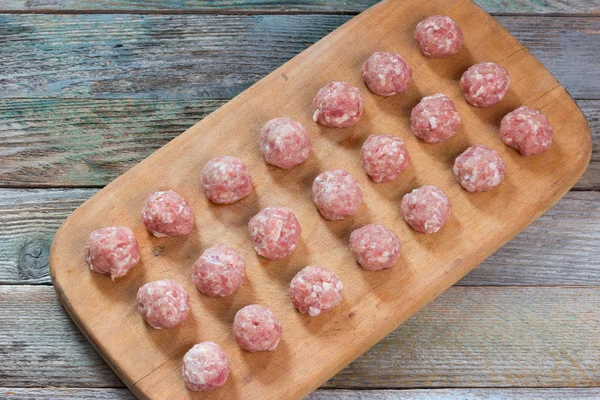 rustik ahşap bir masa, üst üzerinde bir kesim tahta üzerinde ev yapımı köfte closeup görüntülemek