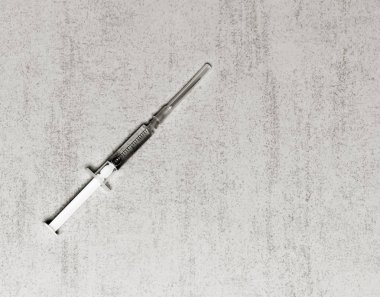 Bir tek kullanımlık tıbbi şırınga için metin alanı olan gri bir arka plan üzerinde bir enjeksiyon iğne. siyah beyaz fotoğraf