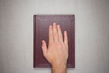 Bir adamın avuç içinde bir kitap, İncil üzerine yemin ettim. Üstten Üstten Görünüm