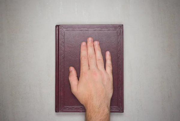Dłoń mężczyzny na książkę, przysięgę na Biblii. Widok z góry z góry — Zdjęcie stockowe