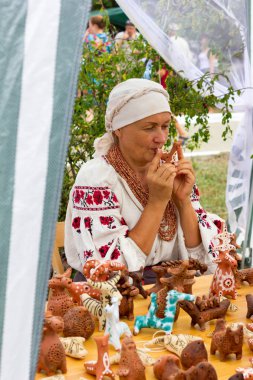 kadın bir kil ıslık kil Hatıra Eşyası ile dükkanda müzik ve oyuncaklar peynir Adıge Çerkezce Festivali'nde çalış