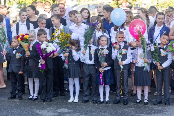 Kinderen ingeschreven in de eerste klas op school, met leraren en ouders bij de inhuldiging van het schooljaar in de dag van kennis — Stockfoto