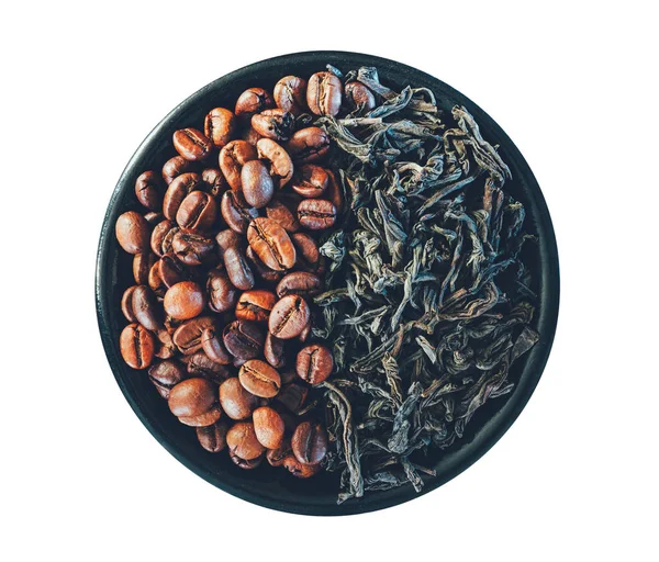 Grains de café et feuilles de thé noir dans une soucoupe isolée sur fond blanc, vue de dessus gros plan — Photo