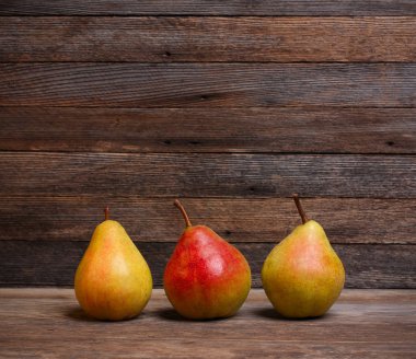 metin alanı olan bir eski ahşap retro arka plan üzerinde üç Olgun tatlı armut