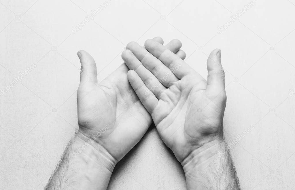 Open mens palms on a gray background top view. black and white photo