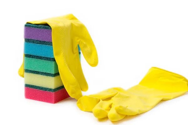 Una pila de esponjas multicolores y guantes de goma amarilla para la limpieza en húmedo y el lavado de platos sobre un fondo blanco con espacio para el texto — Foto de Stock