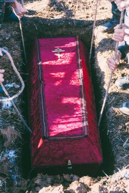 Erkekler tabutu mezara indirdi.