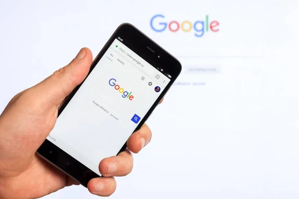 Adygea ロシア連邦 2018 人気のある Web サイト男性の手で中国 Xiaomi スマート フォンの画面でアメリカの検索エンジンの Google — ストック写真