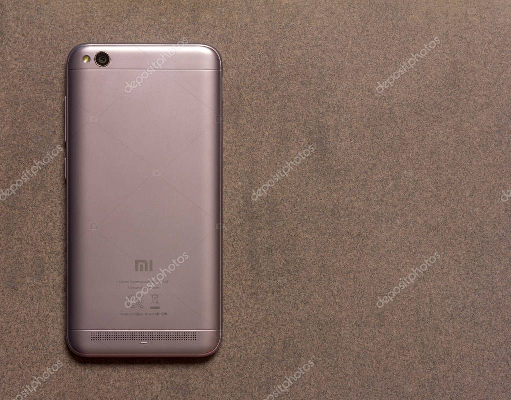 Chinese smartphone Xiaomi Redmi 5A silver back side close up view from above on grey background with copy space
