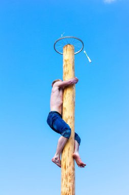 Adıge, Rusya Federasyonu - 12 Mart 2016: adam ahşap kutup için belgili tanımlık ödül karnaval bayram gününde tırmanıyor