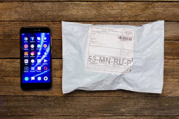 Adıge, Rusya - 24 Ocak 2018: Çin akıllı telefon xiaomi ve ahşap bir masa üstünde belgili tanımlık online stok parsel
