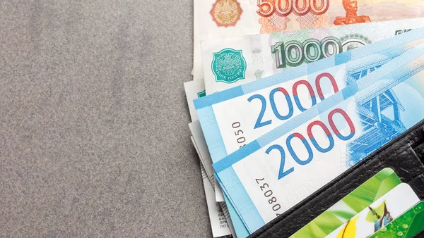 Yeni Rus banknotlar, 1000, 2000 ve 5000 ruble ve siyah deri çanta yakın çekim, kopya alanı ile gri bir arka plan üzerinde üstten görünüm içinde kredi kartları banknottan