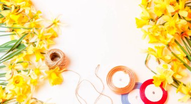 sarı çiçek nergis ve renkli bant ile uzun bir ip üzerinde beyaz bir arka plan, üstten görünüm vardır. metin için yazı için ifadeler için alay