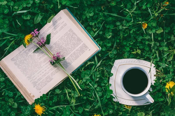 Kitap Kahve Bir Fincan Tabağı Ile Yeşil Bir Yonca Yakın — Stok fotoğraf