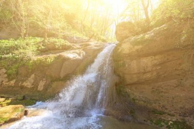 Waterfall on the Mishoko river in the Republic of Adygea spring Sunny morning clipart