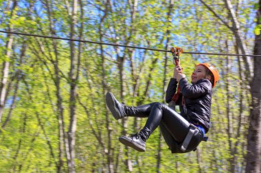 Adıge, Rusya Federasyonu - 15 Nisan 2018: neşeli genç turist kız Zipline üzerinde iner