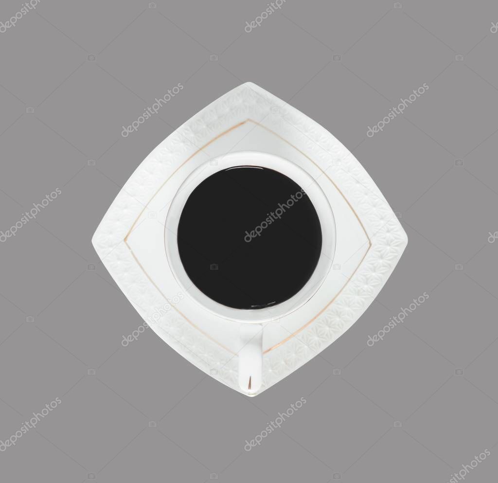 black coffee in white ceramic Cup on saucer isolated on grey background, close-up top view