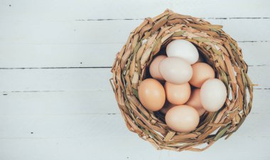 hasır sepet beyaz ahşap arka plan kopya alanı ile üzerinde yerli tavuk yumurta