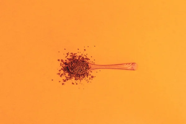 ネオキャロット色のトップビューの背景にインスタントグラニュー糖コーヒーと木製のスプーン 最小限の芸術 — ストック写真