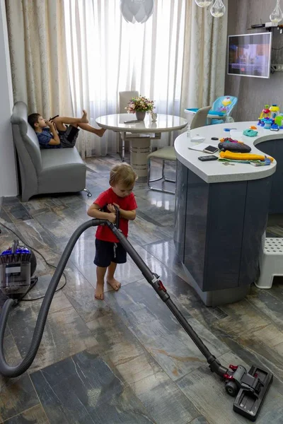 Younger Child Vacuums Floor Living Room Older Brother Sits Idly — Stock Photo, Image