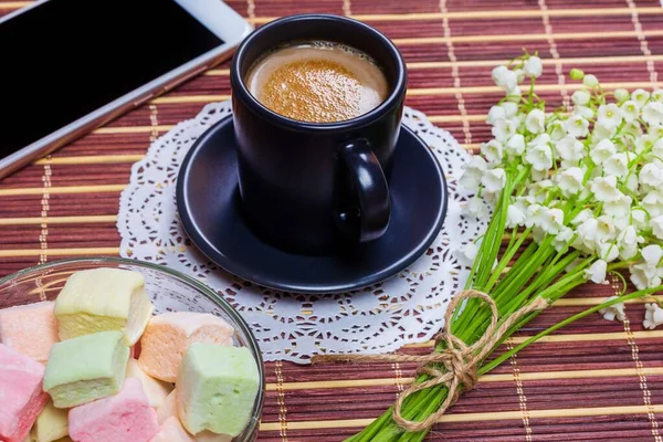 Черная Чашка Кофе Молоком Блюдце Зефир Букет Цветов Долины Смартфон — стоковое фото