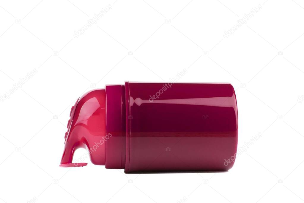 a red plastic bottle with a dispenser containing aftershave, gel or lubricant lies on its side, isolated on a white background