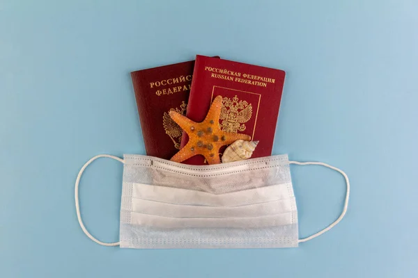 Dwa Rosyjskie Paszporty Rozgwiazda Muszla Pod Jednorazową Maską Medyczną Niebieskim — Zdjęcie stockowe