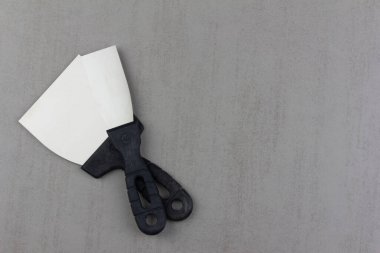 Gri bir arkaplanda iki inşaat spatulası. Kopya alanı ile yakın plan.