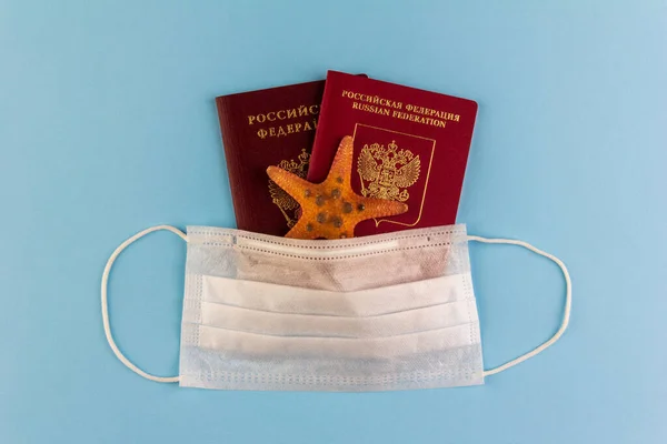 Dwa Rosyjskie Paszporty Rozgwiazda Pod Jednorazową Maską Medyczną Niebieskim Tle — Zdjęcie stockowe