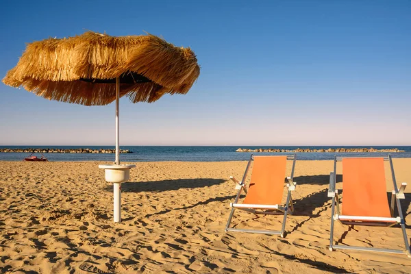 Palm parasole na plaży i molo w tle w Francavill — Zdjęcie stockowe