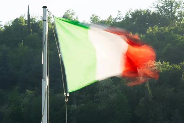 The Italian flag in the wind (blurred) and green in backgroud — Stock Photo, Image