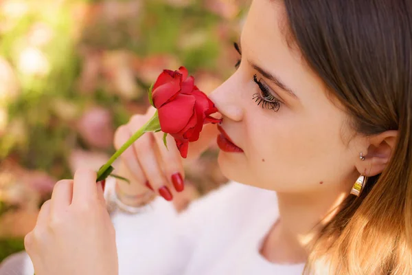 Girl sniffing a red rose in San Valentine day — Stock Photo, Image