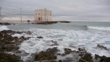 Ostuni, İtalya - 2 Ocak 2018: Kıyı panorama kule ve deniz dalgaları ile