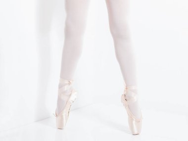 Klasik bir balerin tarafından pembe saten ayakkabılarla ayaklar ve bacaklar