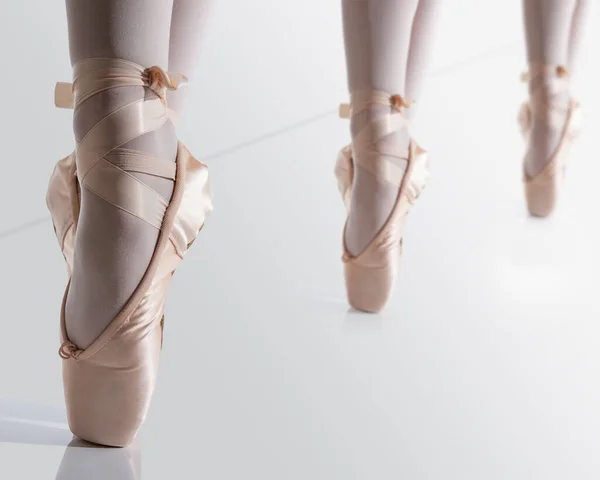 Voeten met roze satijnen puntschoenen van een klassieke ballerina op punt — Stockfoto