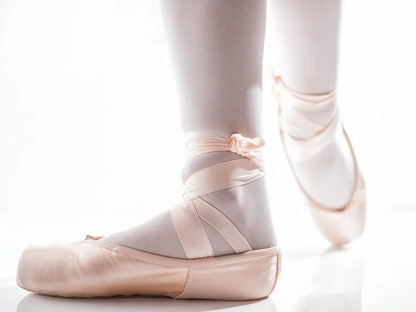 Voeten met roze satijn pointe schoenen door een klassieke danser poseren — Stockfoto