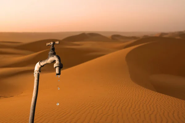 Torneira que goteja e deserto no fundo — Fotografia de Stock