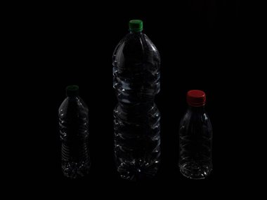 Siyah arka planda şeffaf evcil hayvan şişesi.