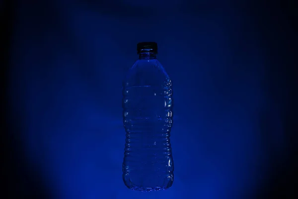 Silhouette de bouteille en plastique usagé sur fond sombre — Photo