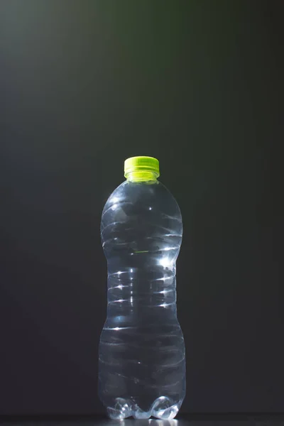 黑暗背景下透明宠物中的空塑料瓶 — 图库照片