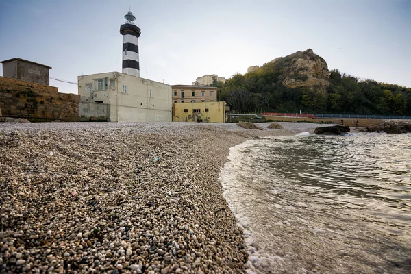 Faro di Ortona i jego żwirowa plaża o zachodzie słońca — Zdjęcie stockowe