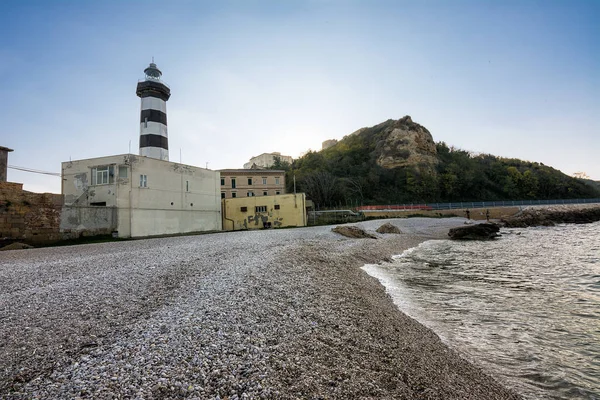 Faro di Ortona i jego żwirowa plaża o zachodzie słońca — Zdjęcie stockowe