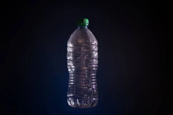 Silhouette de bouteille en plastique transparent utilisé sur fond sombre — Photo