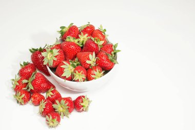 Beyaz arka planda bir kase olgun çilek.