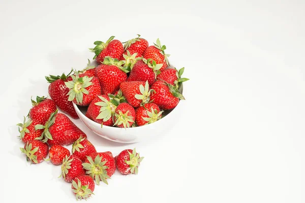 Beyaz arka planda bir kase olgun çilek.