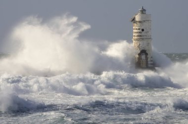 Mangiabarche Deniz Feneri Calasetta Sardinia İtalya. Fırtına sırasında deniz feneri çok yüksek dalgalarla çevrilidir..
