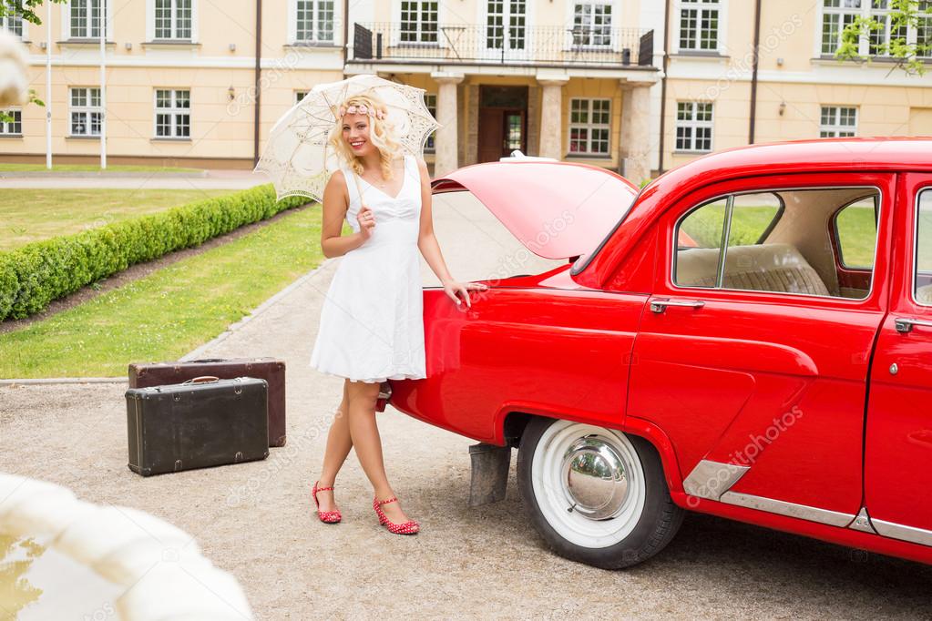 Bright and happy woman with red retro car
